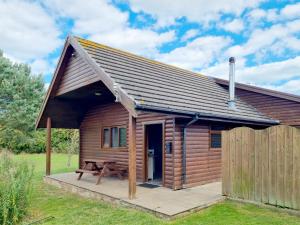 a wooden cabin with a picnic table in front of it at Oak 10 Hot Tub in Garton