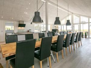 a dining room with a long table and chairs at 14 person holiday home in Læsø in Læsø +13 photos