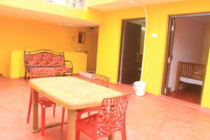 a table and chairs in a room with yellow walls at Villa Lune Home Stay in Puducherry