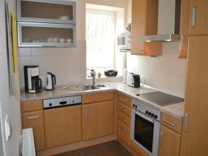 a kitchen with wooden cabinets and a sink at Lindern Woodland Mansion in Werlte