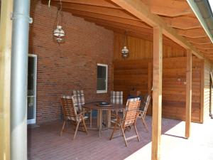 a patio with a table and chairs on a brick wall at Lindern Woodland Mansion in Werlte