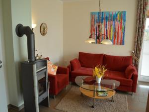 a living room with a red couch and a fireplace at Lindern Woodland Mansion in Werlte +33 photos