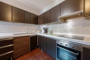 a kitchen with brown cabinets and a sink and a stove at Very Elegant Historic Apartment F2 in Gravedona +27 photos