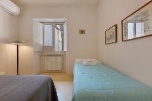 a small room with a bed and a window at Very Elegant Historic Apartment F2 in Gravedona