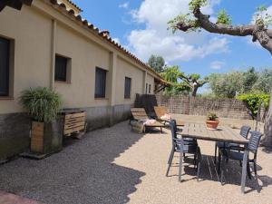 a patio with a table and chairs next to a building at CAN PLANAS Rural in Parlavà