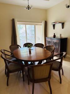 プネにあるSukh Spacious 2BHK in KP Private 4 Balconiesの木製のテーブルと椅子のあるダイニングルーム