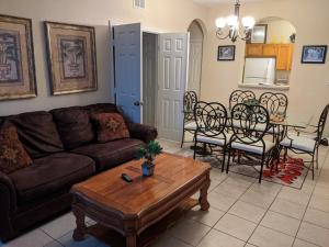 a living room with a couch and a table and chairs at Water Park & Fantastic Pool only Minutes To Walt Disney World's Front Gate!!! in Orlando