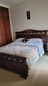 a bed with a wooden headboard in a bedroom at Bel Appartement spacieux 3 pièces avec double salon Paisible & Proche de la Gare d'Agdal in Rabat