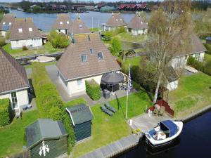 an aerial view of a house with a boat in the yard at Wellness aan het Water in Earnewoude in Earnewâld