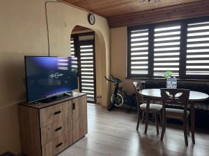 a living room with a tv on a wooden cabinet with a table at Damyanov residence in Pazardzhik