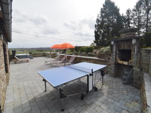 a ping pong table with an umbrella on a patio at Luxury Pool Villa in Goesnes in Goesnes +32 photos