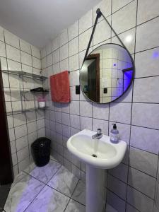 ein Badezimmer mit Waschbecken und Spiegel an der Wand in der Unterkunft Apartamento Sol Nascente no centro da cidade in Cruz das Almas