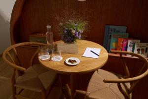 BellevueにあるAuberge Port Gitanaの椅子2脚とボトルとグラスが置かれた小さなテーブル