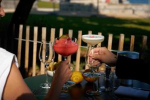 BellevueにあるAuberge Port Gitanaの2人の人が2つのワイングラスを持ってテーブルに座っている