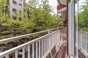 balcón con barandilla blanca y árboles en 1820 - AB Gaudí Avenue Apartment, en Barcelona