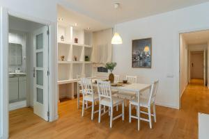 Una cocina y un comedor con una mesa y sillas blancas. en 1820 - AB Gaudí Avenue Apartment, en Barcelona 12 fotos más
