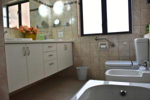 a bathroom with a sink and a toilet and a mirror at Wilderness Whispers in Wilderness