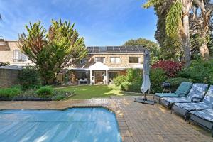 a house with a swimming pool and an umbrella at Dressage Guesthouse in Sweet Valley