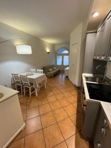 a kitchen and living room with a table and a kitchen and a table and chairs at Maison 24 in Tuscania