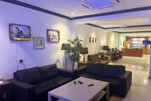 クアラルンプールにあるHotel O Senja Hostel Chinatownのソファとコーヒーテーブルのあるリビングルーム