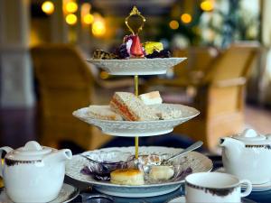 a three tiered tray of desserts on a table with cups at Oak 10 Hot Tub in Garton +8 photos