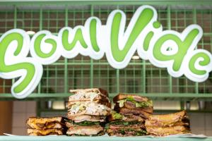 a stack of sandwiches on a plate with a sign at Fera in Belgrade