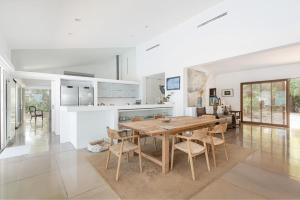 eine Küche und ein Esszimmer mit einem Holztisch und Stühlen in der Unterkunft Es Tamarells -S'Estanyol- in Colònia de Sant Pere