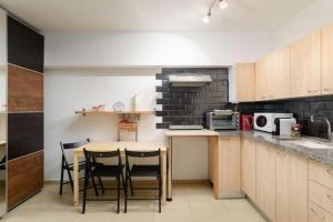 Una cocina con una mesa y algunas sillas. en Netanyas One Bedroom Beachside Escape, en Netanya