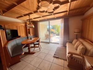 una sala de estar con una mesa y un sofá en Traditional Cozy Apartment, en Tirolo
