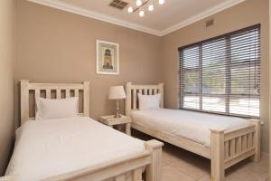 two twin beds in a room with a window at La Toinette 2 in Ballito