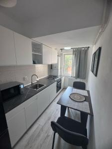 Una cocina con una mesa y sillas y un fregadero. en Angelica Home, en Bucarest