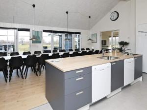 a large kitchen with a long counter and black chairs at 5 star holiday home in Frørup in Frørup