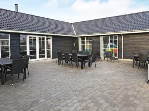 a patio with tables and chairs and a building at 5 star holiday home in Frørup in Frørup