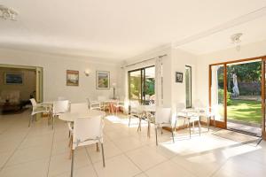 a dining room with white tables and chairs at Dressage Guesthouse in Sweet Valley
