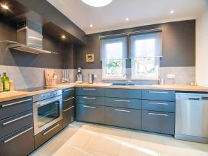 a large kitchen with blue cabinets and a window at Peaceful Durbuy Home & Garden in Durbuy
