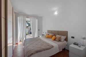 a white bedroom with a large bed with yellow pillows at Vacanza Nel Cuore Del Monferrato in Rocca Grimalda