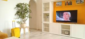 a living room with a television in a white cabinet at DiCaprio - Sunset Ritual incl I by MovieStar Holidays in Mijas Costa