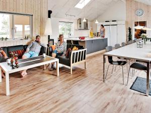 a group of people sitting on couches in a living room at Luxury Retreat with Pool - By Traum Ferienwohnungen in Bogense