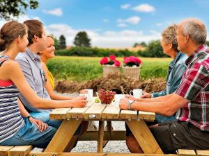 a group of people sitting at a picnic table at Luxury Retreat with Pool - By Traum Ferienwohnungen in Bogense
