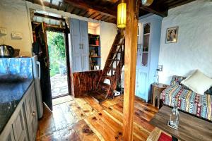 a living room with a wooden floor and a ladder at Parvatis Lap Luxury Hostel & Camps in Kasol