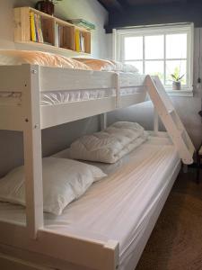 two bunk beds with pillows on them in a room at Nordic Holiday Home With Fjord Views On Enø in Karrebæksminde