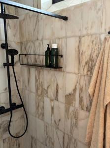 a bathroom with a shower with marble tiles at Nordic Holiday Home With Fjord Views On Enø in Karrebæksminde