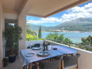a table on a balcony with a view of the water at Apartment Zahna in Njivice