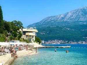 a beach with a group of people in the water at Apartment Zahna in Njivice +26 photos
