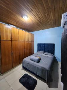 a bedroom with a bed and wooden cabinets at Casa con patio y quincho en Cambyreta Itapua in Encarnación +15 photos