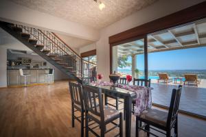 a dining room with a table and chairs and a staircase at Castelli by Vintage Travel in Lagópodhon