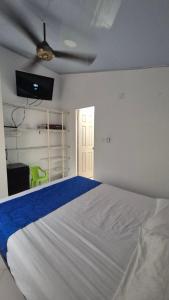 a white bedroom with a bed and a ceiling fan at Casa Dante in Melgar