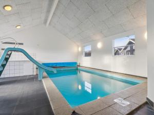a swimming pool with a slide in a building at Luxury Pool Villa in Bagenkop - By Traum Ferienwohnungen in Bagenkop