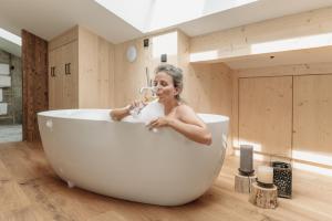 una donna è seduta in una vasca da bagno e beve di grainau1 boutique apartments a Grainau Altre 60 foto