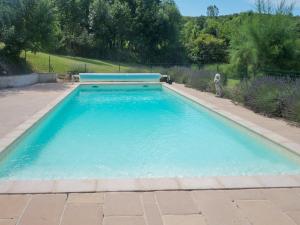 a swimming pool with blue water in a yard at Historic Village Escape w Pool in Saint-Beauzile